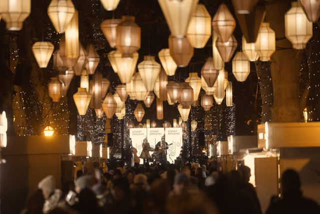The audience under hanging lamps at an evening concert