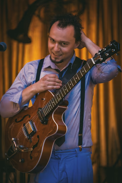 The guitarist in braces with a red guitar