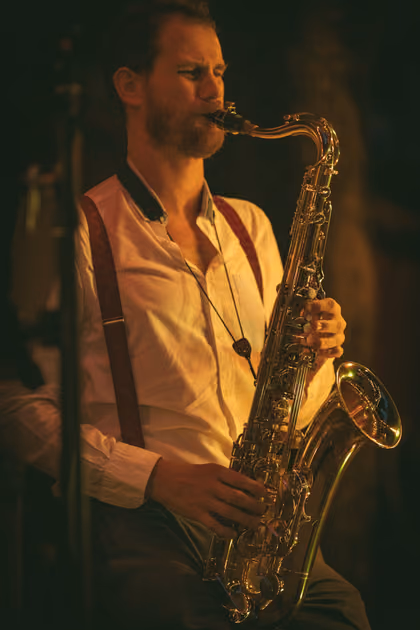 The saxophonist in a light shirt and braces