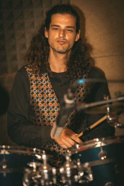 The drummer with long curls at his kit