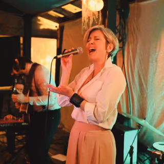 The singer in a white shirt singing in a club